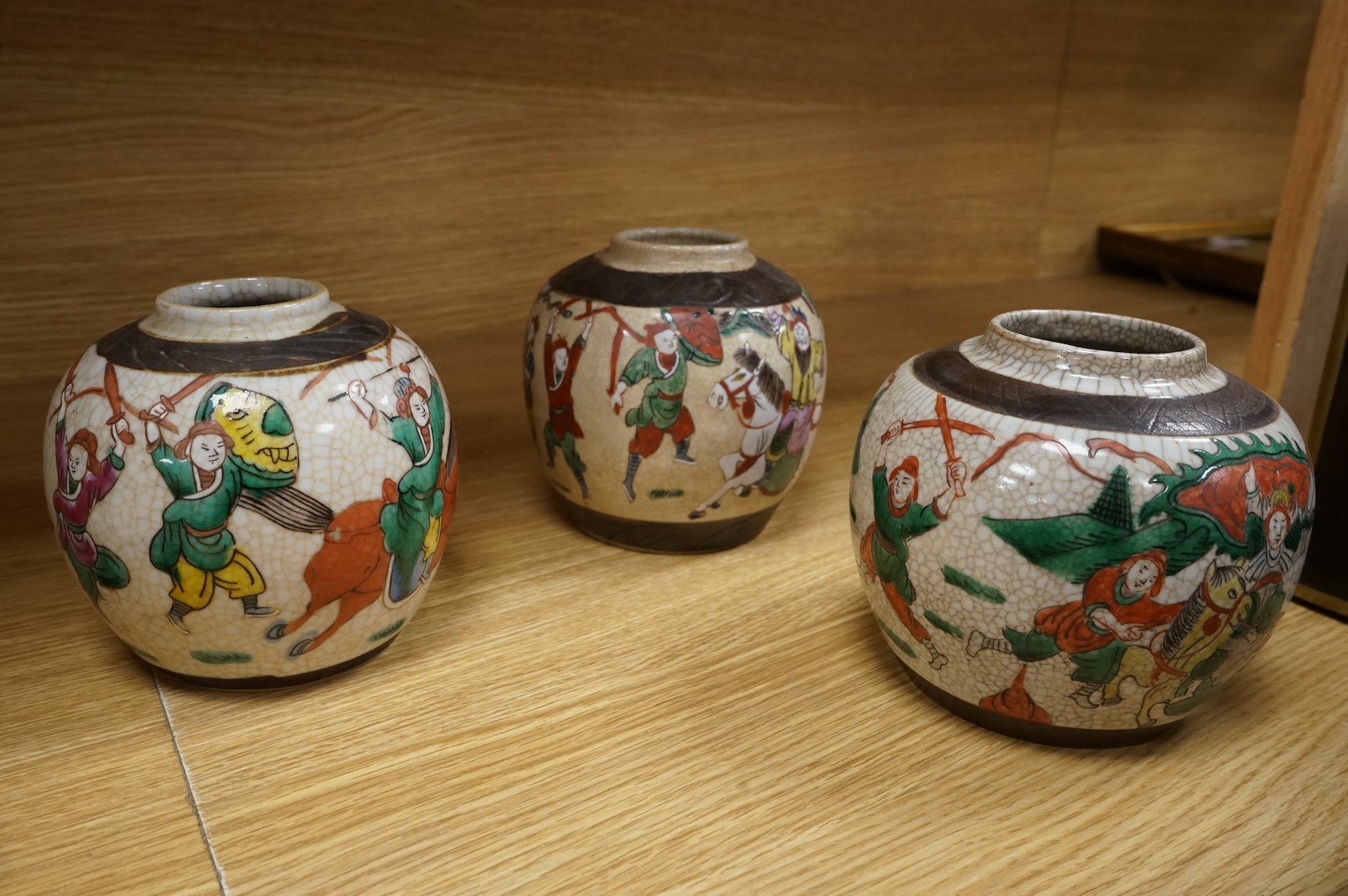 Three Chinese crackleglaze 'Warriors' jars without covers and two Chinese enamelled porcelain bowls. Largest bowl 20cm diameter.